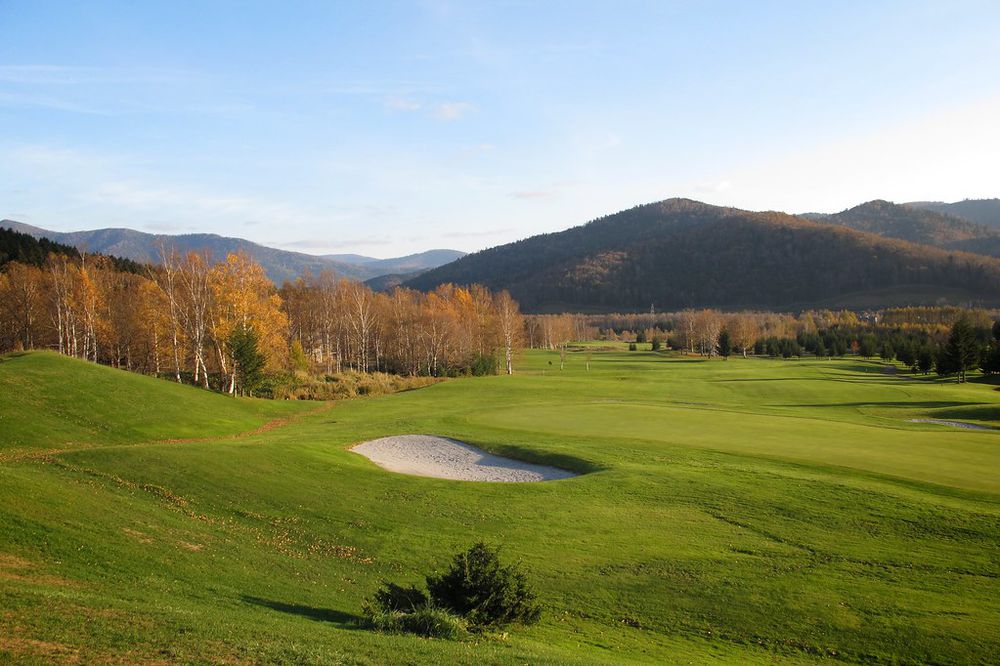 A green golf fairway among autumn hills in Japan